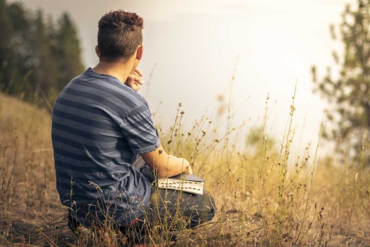 A man in nature meditating and praying